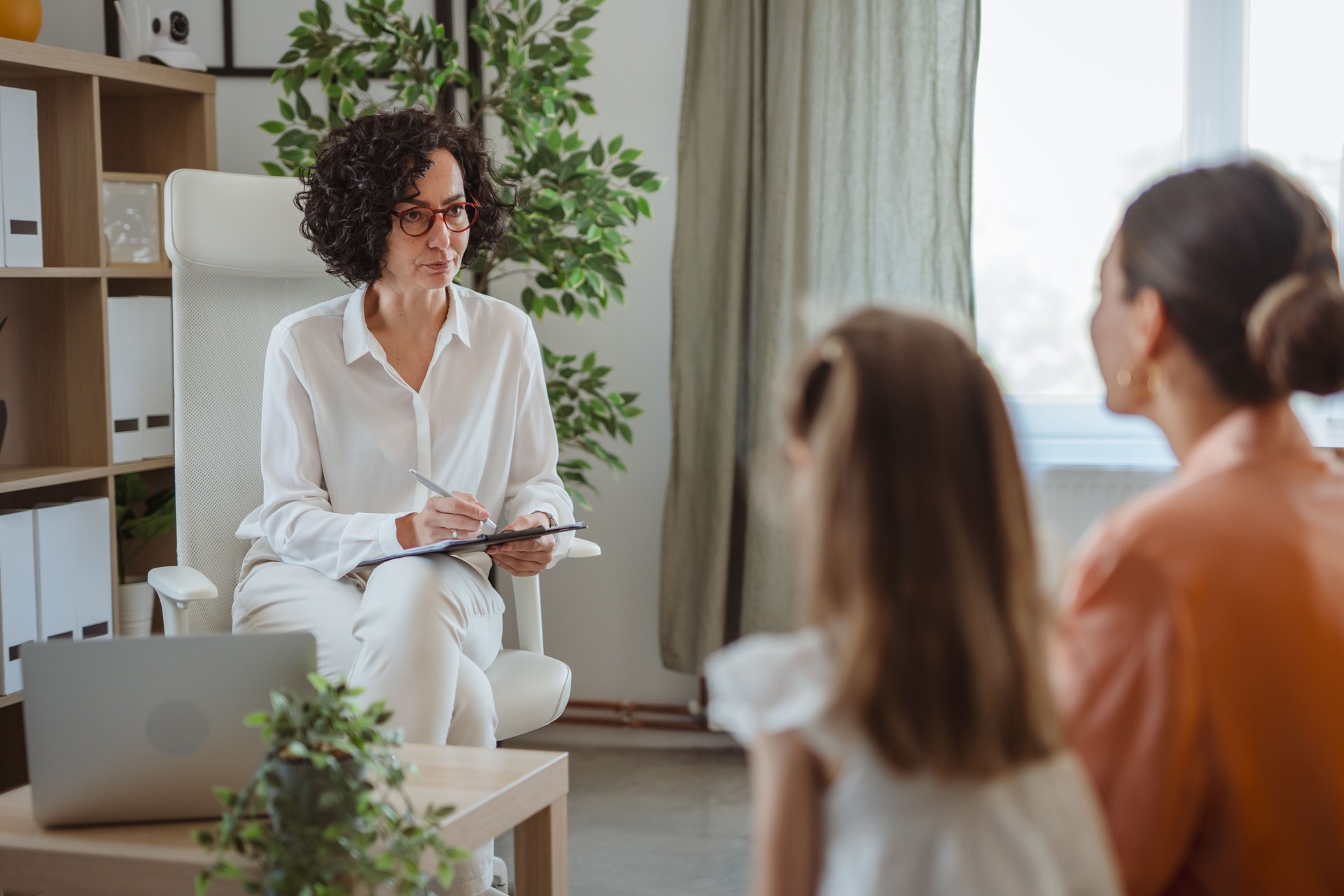 Counselor with child and parent in therapy session
